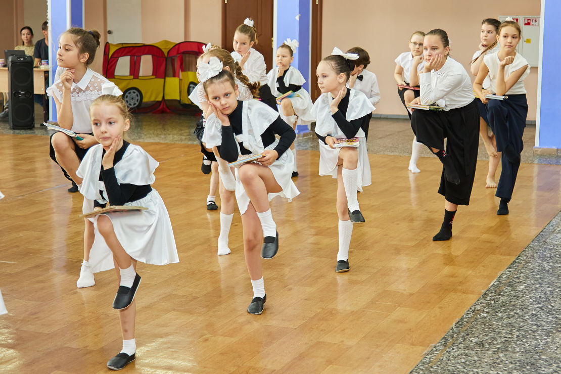 Дети в школьной форме Советского Союза танцуют в зале